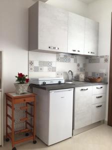 eine Küche mit weißen Schränken und einer Arbeitsplatte in der Unterkunft Lu Caleddhu in Specchia