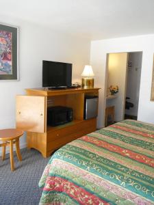 a hotel room with two beds and a flat screen tv at Colusa Riverside Inn in Colusa