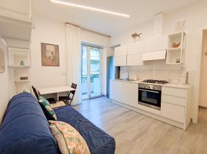 een woonkamer met een bank en een keuken bij Casa di Bubs - By Ligooria in Pietra Ligure