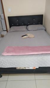 ein Bett mit einer Decke und einem Buch darauf in der Unterkunft Dom Antonio 3 in Campos dos Goytacazes