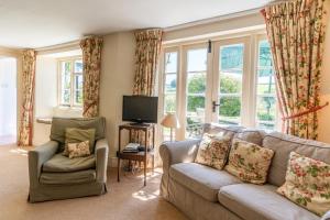 a living room with a couch and a chair and windows at Finest Retreats - Valley Cottage in Withypool