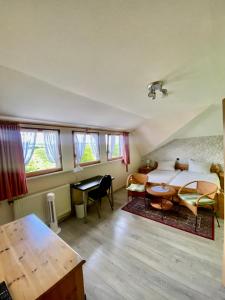 Schlafzimmer mit einem Bett, einem Schreibtisch und einem Tisch in der Unterkunft Rheingoldschänke in Oberwesel