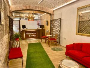 バルセロナにあるÀmfores Boutique Guest Houseのリビングルーム(赤いソファ、緑の敷物付)