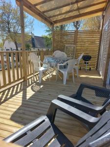 a wooden deck with a table and chairs on it at CARNAC Mobil-Home Camping 4 étoiles in Carnac