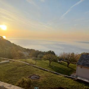een uitzicht op de oceaan bij zonsondergang vanuit een huis bij Extraordinaire guest house sur la route de Pozzo in Brando