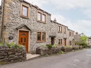 a stone house with a wooden door on a street at Top House in Settle