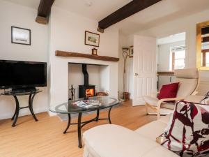 een woonkamer met een tafel en een open haard bij Top House in Settle