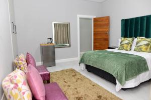 a bedroom with a bed and a chair and a mirror at Olive Boutique in Johannesburg +107 photos