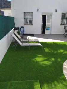 un patio con césped verde y sillas en el techo en Casa Cristy, en Montejaque