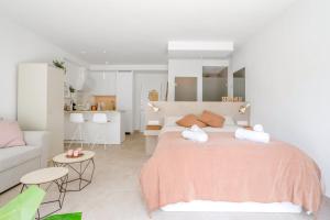 um quarto branco com uma cama grande e um sofá em OleHolidays 413 Romana Playa Primera línea playa em Marbella