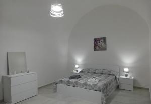 a bedroom with a bed and two dressers and a mirror at Maison de Marie in Trani