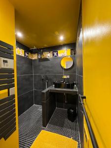 baño con lavabo y pared amarilla en Le Regardeur en Saint-Rémy-de-Provence