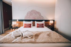 a bedroom with a large white bed with red pillows at Villa Amistà Campos do Jordão in Campos do Jordão