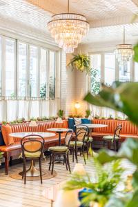 a restaurant with tables and chairs and windows at SIXTY Beverly Hills in Los Angeles