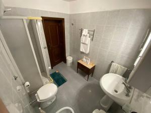 a bathroom with a white toilet and a sink at Villa Viola in Torre Chianca