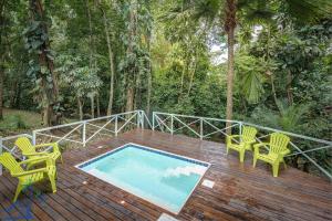 a wooden deck with chairs and a swimming pool at Lovely Casa Cucula Pool House with FiberOp in Cocles