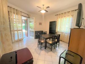 een eetkamer met een tafel, stoelen en een televisie bij Villa Giulia in Bibione +9 foto's