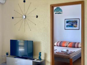 Pokój z lustrem, telewizorem i łóżkiem w obiekcie Apartmani Janja w Krku