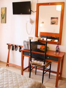 a bedroom with a desk with a mirror and a chair at PANSION KONSTANTINOS in Skiathos +53 photos