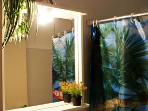 a bathroom with a window with potted plants on a shelf at PANSION KONSTANTINOS in Skiathos
