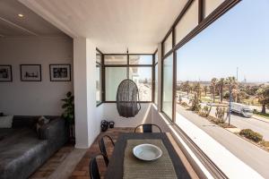 a living room with a table and a large window at Cremorne on Beach Road in Summerstrand