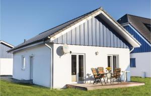 a white house with chairs and a table on a deck at Ferienhaus 11 Altefhr in Altefähr