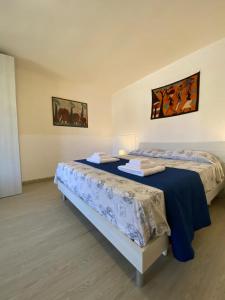 - deux lits dans une chambre avec deux couvre-lits dans l'établissement Villa Viola, à Torre Chianca
