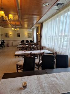 a dining room with tables and chairs and windows at Casa Palace in Timişoara