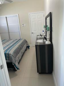 a bedroom with a bed and a mirror on a dresser at Aquamarine Resort-style Vacations in Lucea