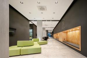 eine Lobby mit grünen Stühlen in einem Gebäude in der Unterkunft Intercity Canoas in Canoas + 28 Fotos