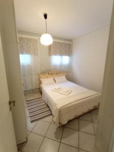 ein Schlafzimmer mit einem großen Bett in einem Zimmer in der Unterkunft Galini apartment near sea, port and airport in Artemida