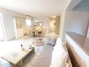 ein Wohnzimmer mit einem Sofa und einem Tisch in der Unterkunft Galini apartment near sea, port and airport in Artemida