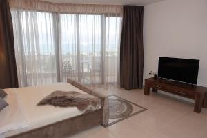 a living room with a couch and a flat screen tv at Millennium Apart Complex in Sveti Vlas