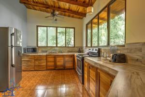 a large kitchen with wooden cabinets and wooden floors at Beachfront Villa Sea Breeze w AC and POOL in Puerto Viejo