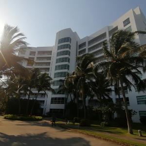 een groot gebouw met palmbomen ervoor bij Mayan Lake Horus in Acapulco