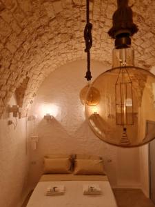 een kroonluchter boven een tafel voor een stenen muur bij Lory's Luxury Suite Ostuni in Ostuni