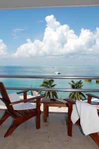 a balcony with a table and chairs and the ocean at Bahia Chac Chi - Adults Only in Isla Mujeres
