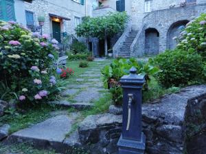 un buzón azul en un jardín con flores y un edificio en B&B Alle Ortensie Blu, en Sesta Godano