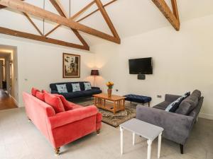 a living room with two couches and a tv at The Old Stables in Gillingham