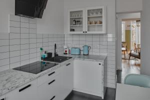 a white kitchen with a sink and a counter top at Apartament D16 in Pińczów