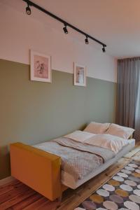 a bedroom with a bed with a yellow frame at Apartament D16 in Pińczów