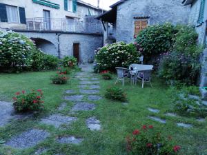 un giardino con tavolo, sedie e fiori di B&B Alle Ortensie Blu a Sesta Godano