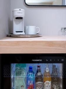 a refrigerator with bottles of soda and a coffee maker at Hotel Hygge in Buellton