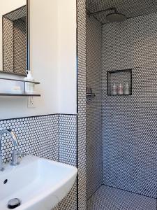 La salle de bains est pourvue d'une douche et d'un lavabo. dans l'établissement Hotel Hygge, à Buellton