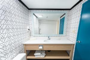 a bathroom with a sink and a mirror at Sternwheeler Hotel & Conference Centre, Trademark by Wyndham in Whitehorse