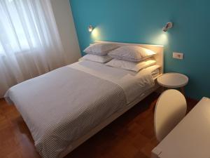 a bedroom with a white bed with a blue wall at Apartments Leo in Rovinj