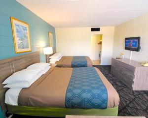 a hotel room with two beds and a television at Beach Carousel Virginia Beach in Virginia Beach