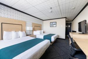 a hotel room with two beds and a flat screen tv at Sternwheeler Hotel and Conference Centre in Whitehorse