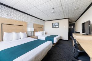 a hotel room with two beds and a flat screen tv at Sternwheeler Hotel & Conference Centre, Trademark by Wyndham in Whitehorse