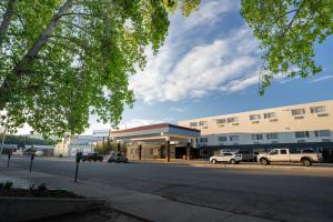 a building with cars parked in front of a street at Sternwheeler Hotel & Conference Centre, Trademark by Wyndham in Whitehorse